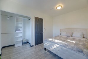 A bedroom with a bed, a wardrobe, and a door. - Walkable Location! Spacious Huntington Park Home (Huntington Park)