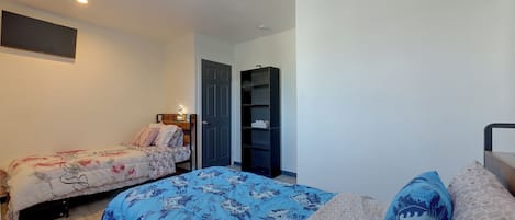 Ein Schlafzimmer mit zwei Betten, einem Kleiderschrank und einer Regaleinheit.