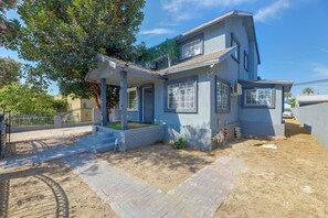 A two-story house with a covered porch and a small front yard. - Walkable Location! Spacious Huntington Park Home (Huntington Park)