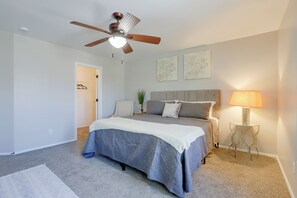 A bedroom with a bed, a ceiling fan, a bedside lamp, and a door leading to a closet. - Extended Stay w/ Pool Access, Near Queen Creek (San Tan Valley)