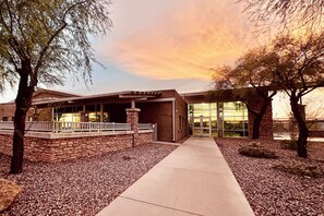 A building with a brick facade, a covered walkway, and a glass entrance. - Extended Stay w/ Pool Access, Near Queen Creek (San Tan Valley)