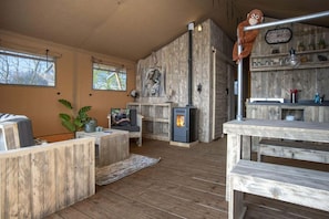 A rustic interior with a fireplace, wooden furniture, and a shelf with various items.