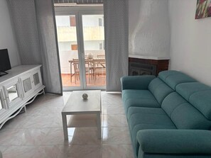 A living room with a sofa, a coffee table, and a TV stand. - ResbalajeHomes Granada 75 1A (Nerja)