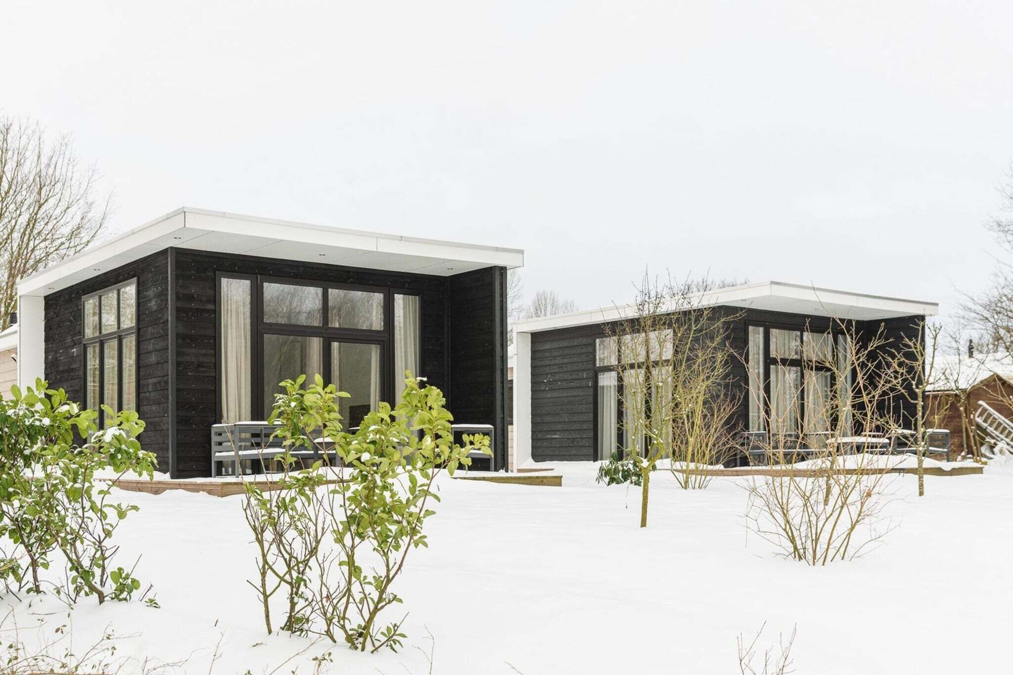 A modern two-story house with large windows and a flat roof.