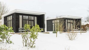 Una casa moderna de dos pisos con ventanas amplias y techo plano.