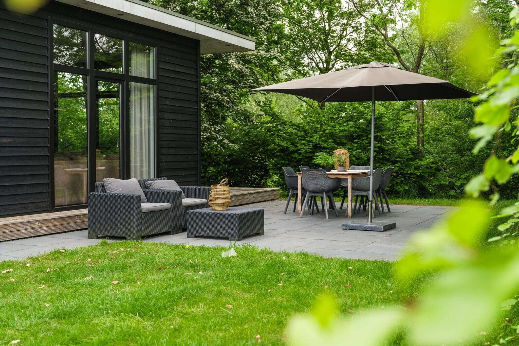 A patio with outdoor furniture, a table, and an umbrella.