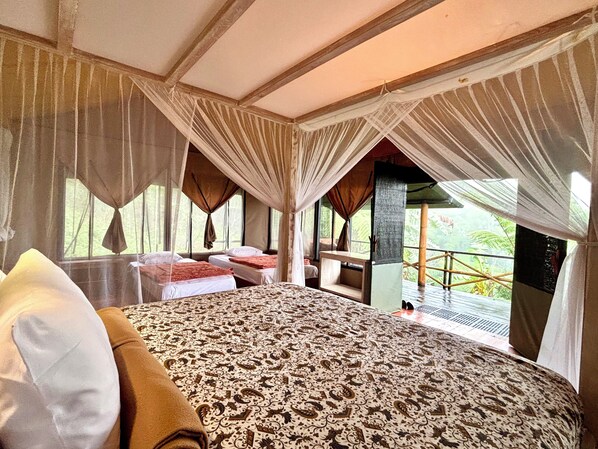 A room with a bed, a bench, and a view of the outdoors.