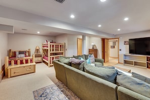 A living room with a sofa, a television, a bunk bed, and a lamp. - All-Season Family Cabin w/ Forest Views in Truckee (Truckee)