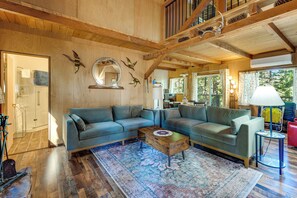 A spacious living room with a large sectional sofa, a coffee table, and a patterned rug.