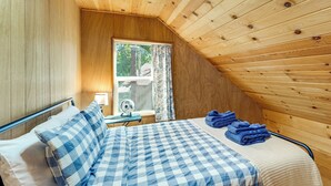 Ein Zimmer mit einem Bett, einem Fenster, einem Ventilator und Blick ins Freie.