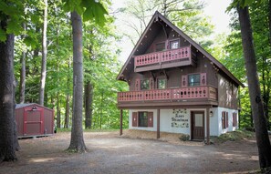 A two-story cabin with a balcony, surrounded by trees. - 'StrautmanHaus' All-Season Berkshire East Chalet (Charlemont)