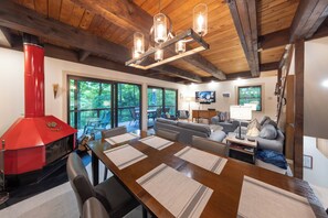 A spacious living area with a dining table, sofas, and a red fireplace. - 'StrautmanHaus' All-Season Berkshire East Chalet (Charlemont)