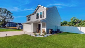 A two-story house with a garage, a front porch, and a well-maintained lawn. - Family Home w/ Game Room, Near Lake Hartwell! (Anderson)