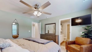 A bedroom with a bed, a ceiling fan, a dresser, a mirror, a TV, and a plant. - Family Home w/ Game Room, Near Lake Hartwell! (Anderson)