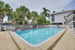 A rectangular swimming pool with a tiled edge, surrounded by lounge chairs and palm trees. - Steps to Sand! Extended Bradenton Beach Getaway (Bradenton Beach)