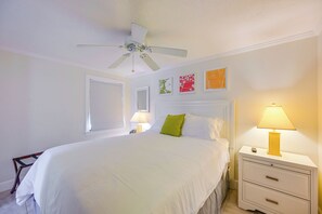 A hotel room with a bed, bedside lamps, a nightstand, a drawer unit, and a ceiling fan. - 2 Mi to Beach! Naples Park Bungalow (Naples)
