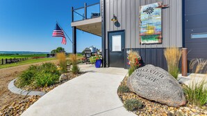 A modern building with a large rock inscribed with 'ALLVIEW REFUGE EST. 2025' in front.