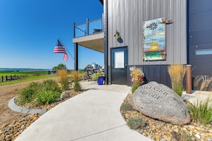 A modern building with a large rock inscribed with 'ALLVIEW REFUGE EST. 2025' in front.