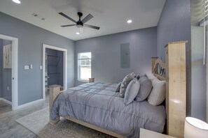 A bedroom with a bed, a ceiling fan, a window, and a door. - Gateway to State Park & Lake! Inviting Vian Cabin (Vian)