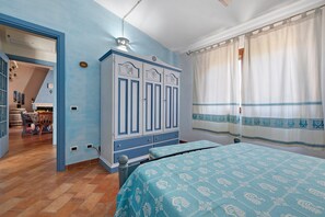 A bedroom with a bed, wardrobe, and a view of a dining area. - Holiday Home 'Tanit' with Private Terrace, Wi-Fi and Air Conditioning (Villasimius)