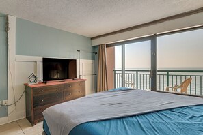 A bedroom with a bed, a dresser, a television, and a view of the sea through a balcony. - 14th-Floor Ocean View + Pools! Myrtle Beach Haven (Myrtle Beach)