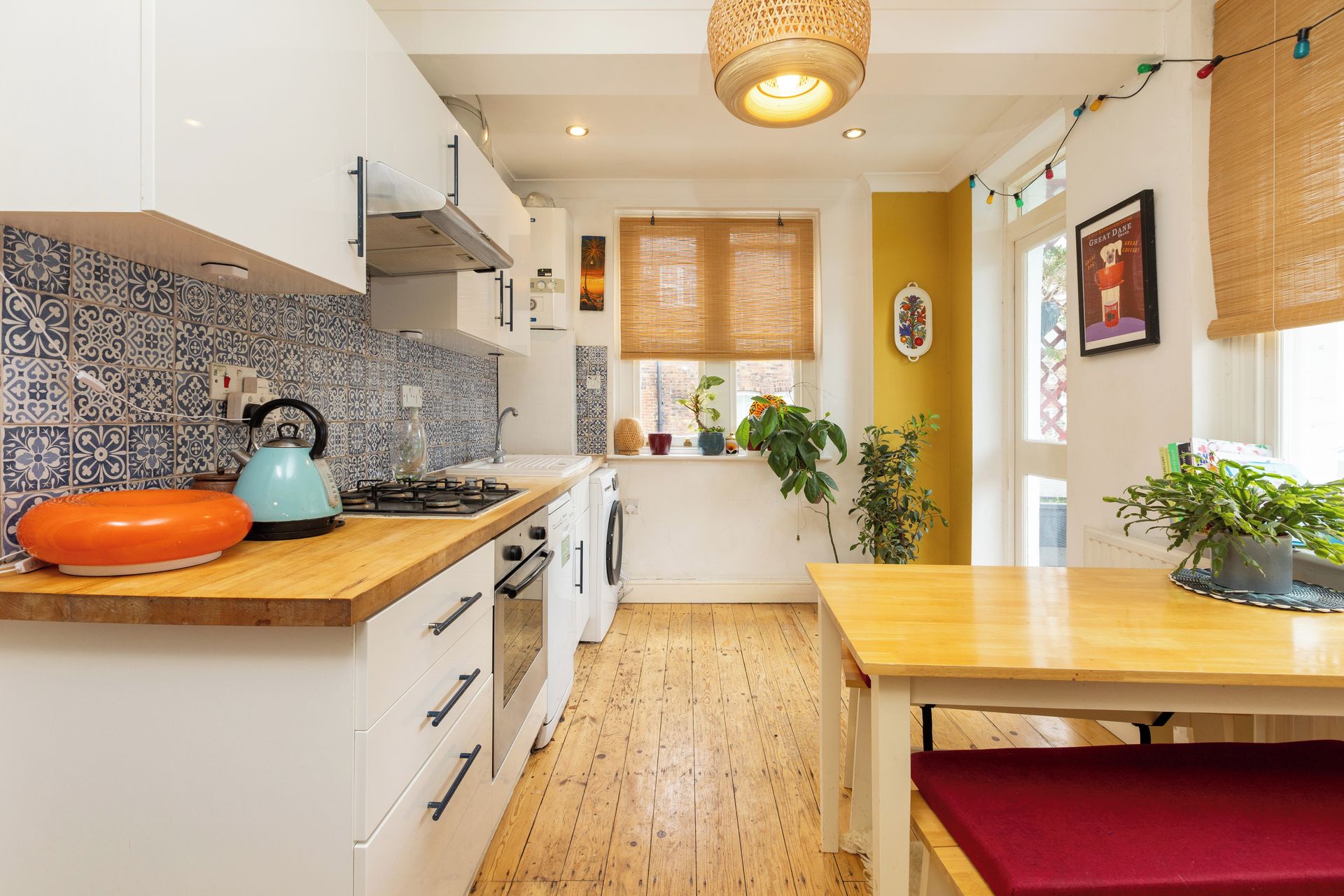 A compact kitchen with a stove, sink, and wooden countertops.