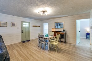 Un espace repas comprenant une table et des chaises, un ventilateur de plafond et une porte avec une fenêtre.
