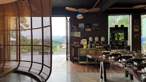 A restaurant with a view of the mountains, a bar area with various bottles, and a buffet setup. - Evergreen Forest Retreat Zhangjiajie (Zhangjiajie)