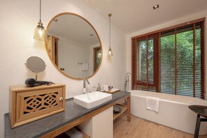 A modern bathroom with a large mirror, a sink, a bathtub, and a window with blinds. - Evergreen Forest Retreat Zhangjiajie (Zhangjiajie)