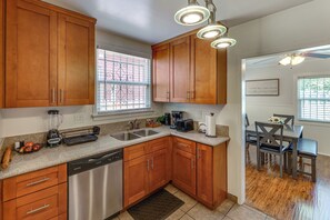 A kitchen with wooden cabinets, a dishwasher, a double sink, and a coffee maker. - Walk to Metro! Historic View Park Home w/ Patio (Los Angeles)