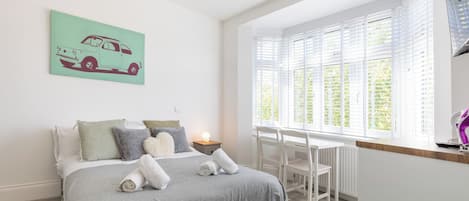 Tabla de planchar con plancha, internet y ropa de cama