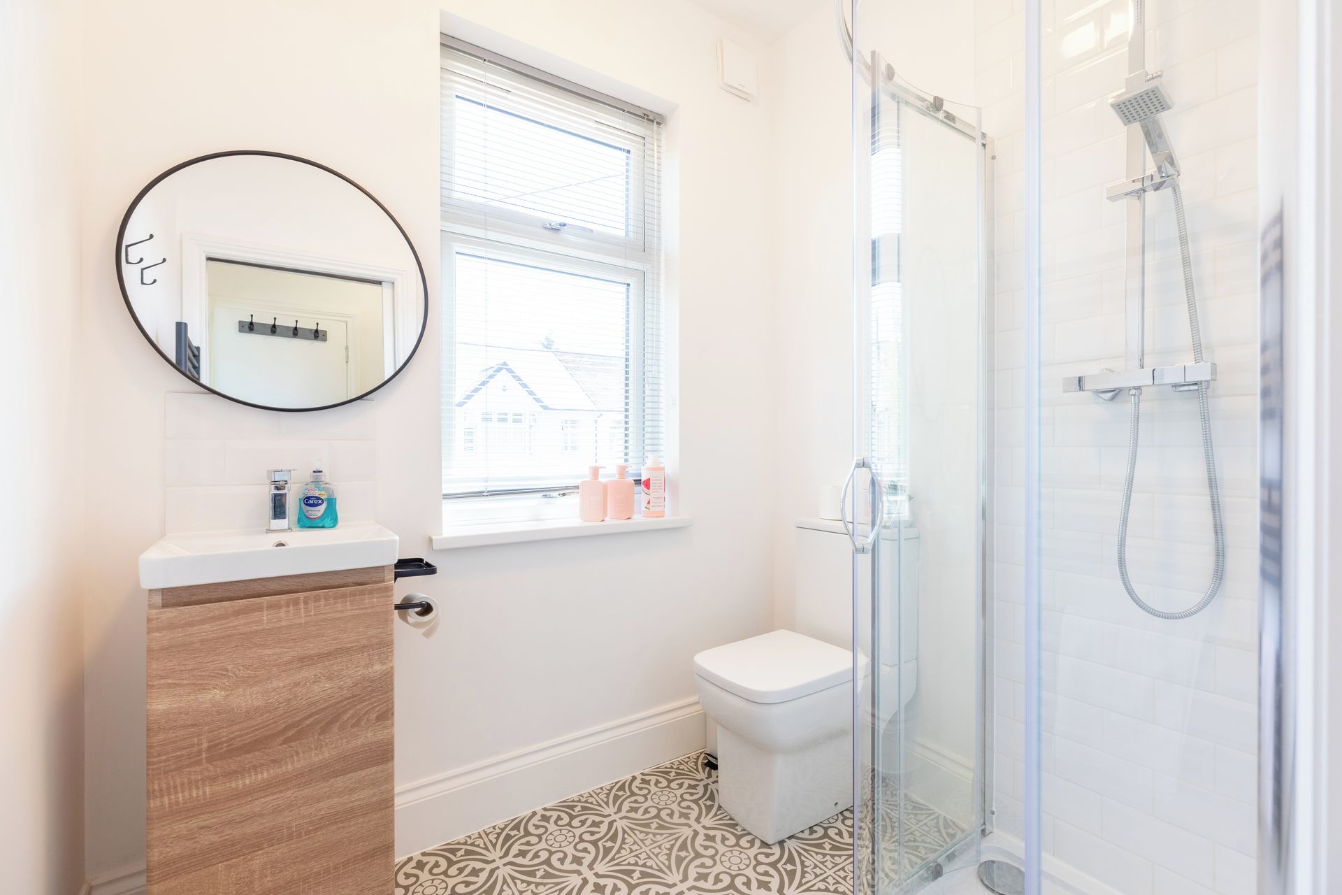 Ein Badezimmer mit Toilette, einem Waschbecken mit Spiegel und einer Duschkabine.