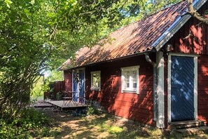 A red wooden house with a porch, a door, and a window. - 3 person holiday home in BORGHOLM (BORGHOLM)