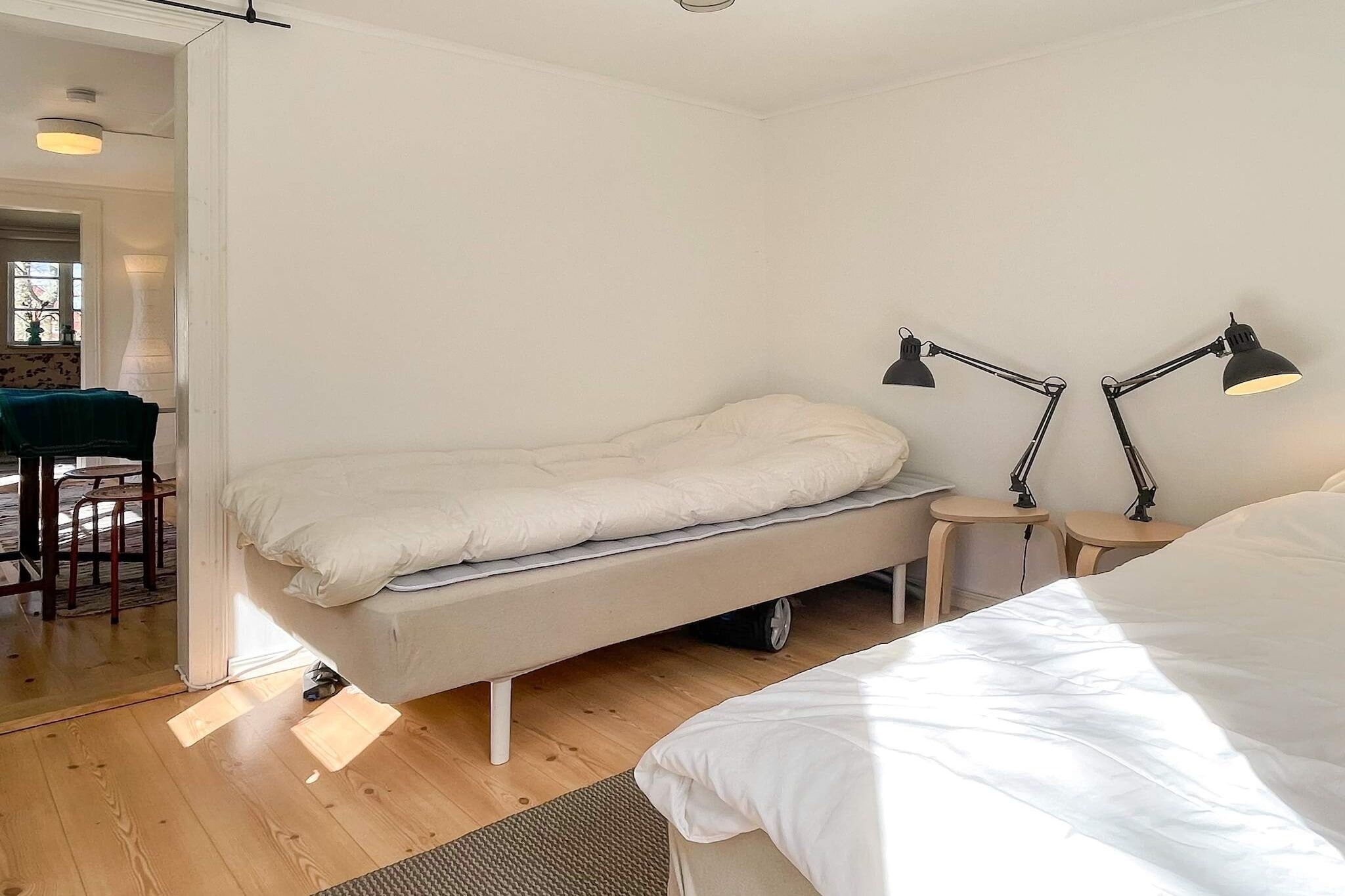 Une chambre à coucher au style minimaliste, avec un lit, des tables de chevet et un bureau.