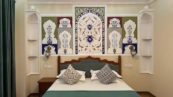 A bedroom with a large bed, decorative wall panels, and a chandelier.