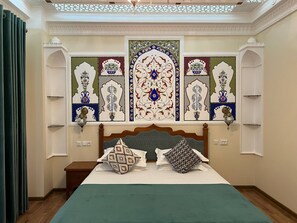 Un dormitorio con una cama grande, paneles decorativos en la pared y un candelabro.