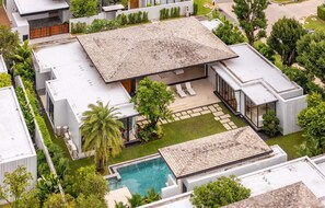 Een modern huis met een zwembad, terras en een verzorgde tuin.