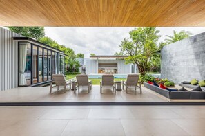 A modern outdoor patio with a pool, seating area, and a view of the surrounding garden. - Botanica Forestique 4br Luxury Retreat (Choeng Thale)