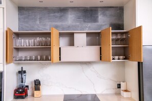 A kitchen with open cabinets displaying glassware and a blender on the counter. - Botanica Forestique 4br Luxury Retreat (Choeng Thale)