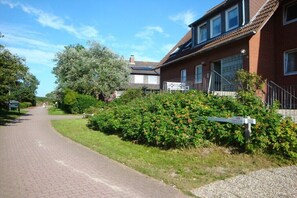 En bostadsgata med hus, en asfalterad väg och en vägskylt.