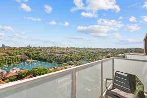 Un balcon avec vue sur un port de plaisance et sur le paysage urbain.