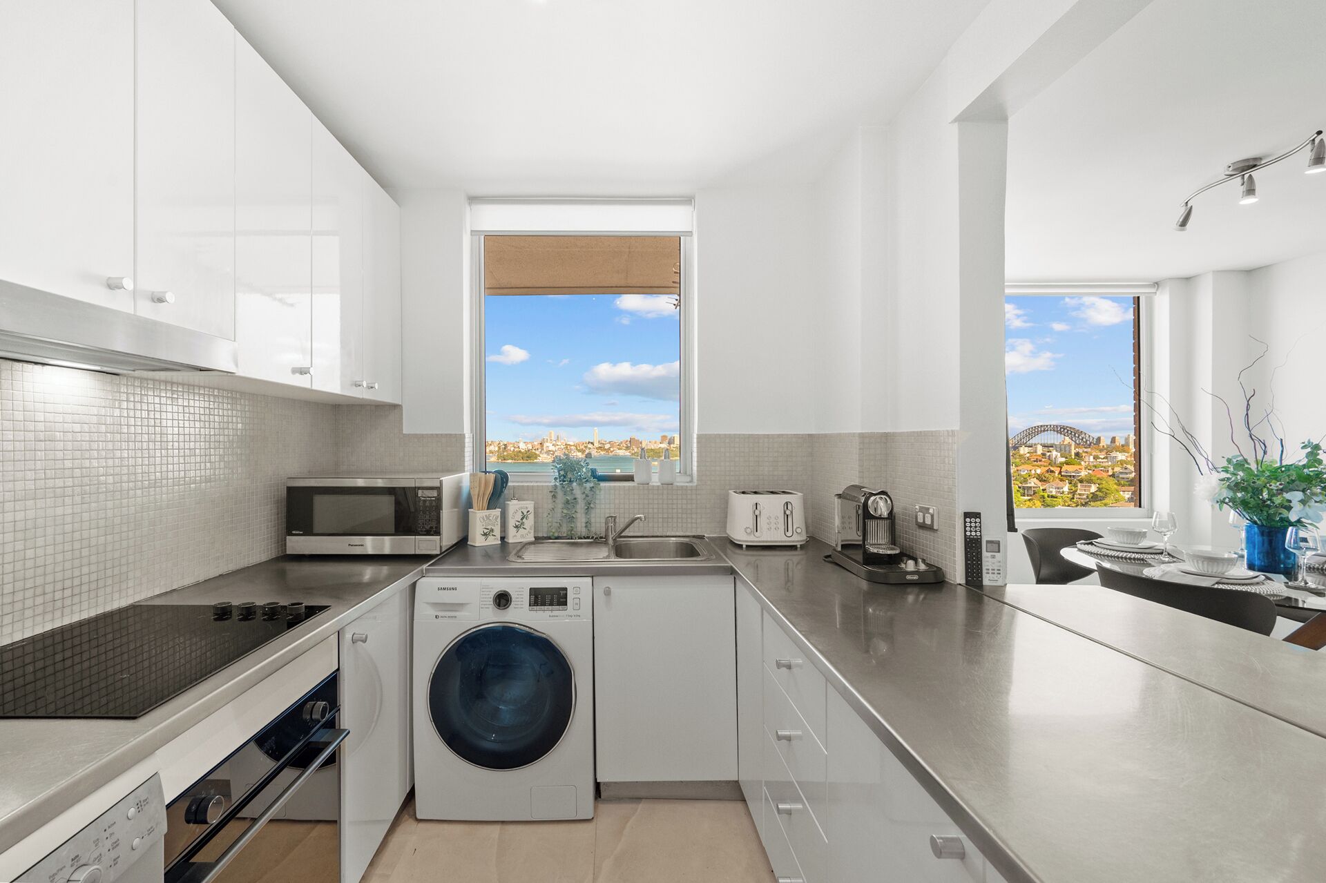 A modern kitchen with a built-in washer, a microwave, and a toaster.