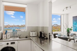 Une cuisine moderne avec vue sur le paysage urbain, une machine à café et un lave-linge.