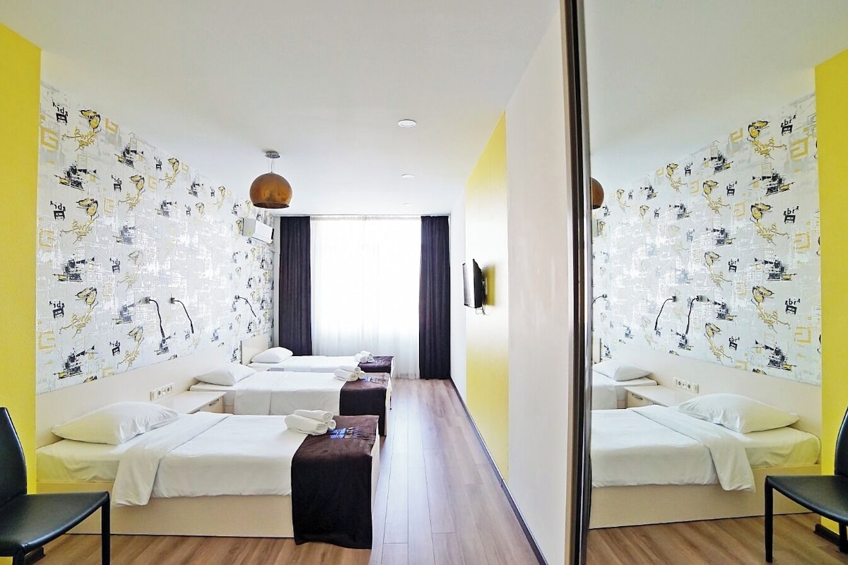 A hotel room with two beds, a desk, and a chair.