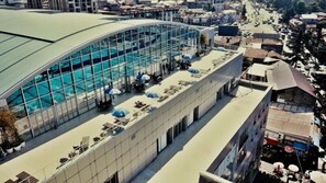 A hotel with a large glass pool and outdoor seating. - Plaza Inn Batumi (Batumi)