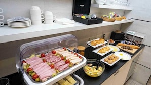 Montaje de bufé con diversos alimentos, como carnes, quesos y pasteles.