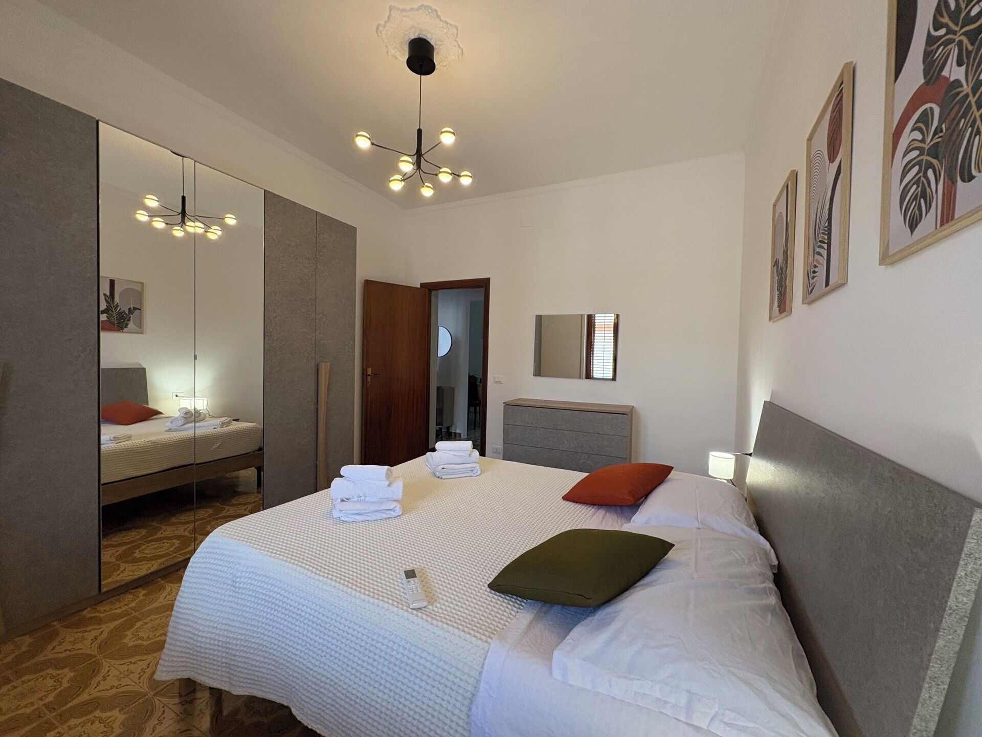 Una camera d'albergo con un letto grande, uno specchio, un comodino e un armadio.