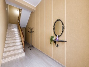 Eine Holztreppe mit Geländer, die zu einer Zwischenebene führt.