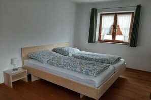 A single bed with a wooden frame and a nightstand with a lamp. - Holiday apartment with 2 bedrooms (Mittenwald)