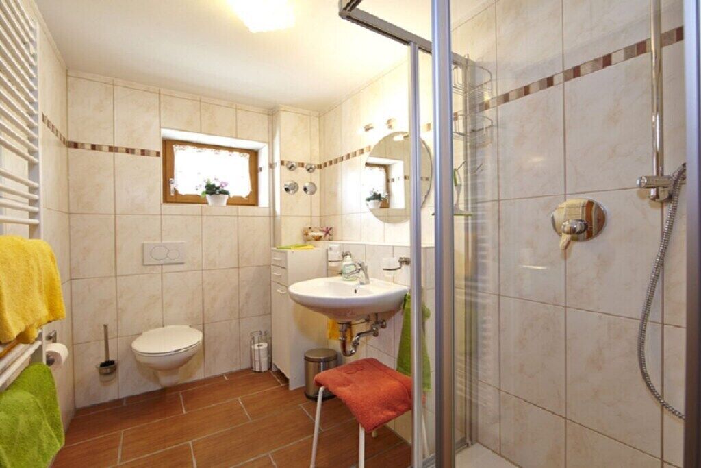 Een badkamer met toilet, wastafel en douche.